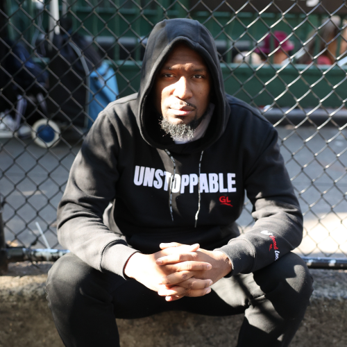 man in hoodie sitting on curb