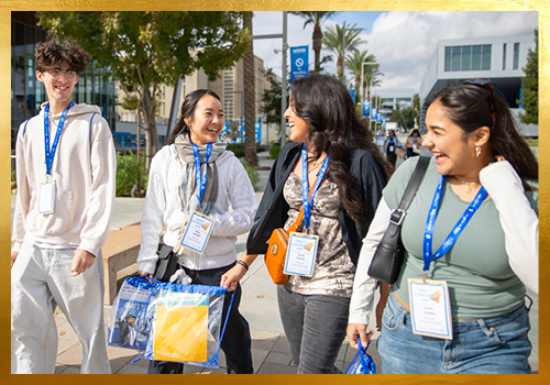 Four students walking and laughing