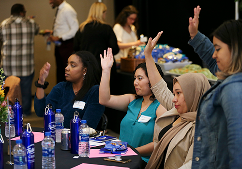 Four women raising their hands