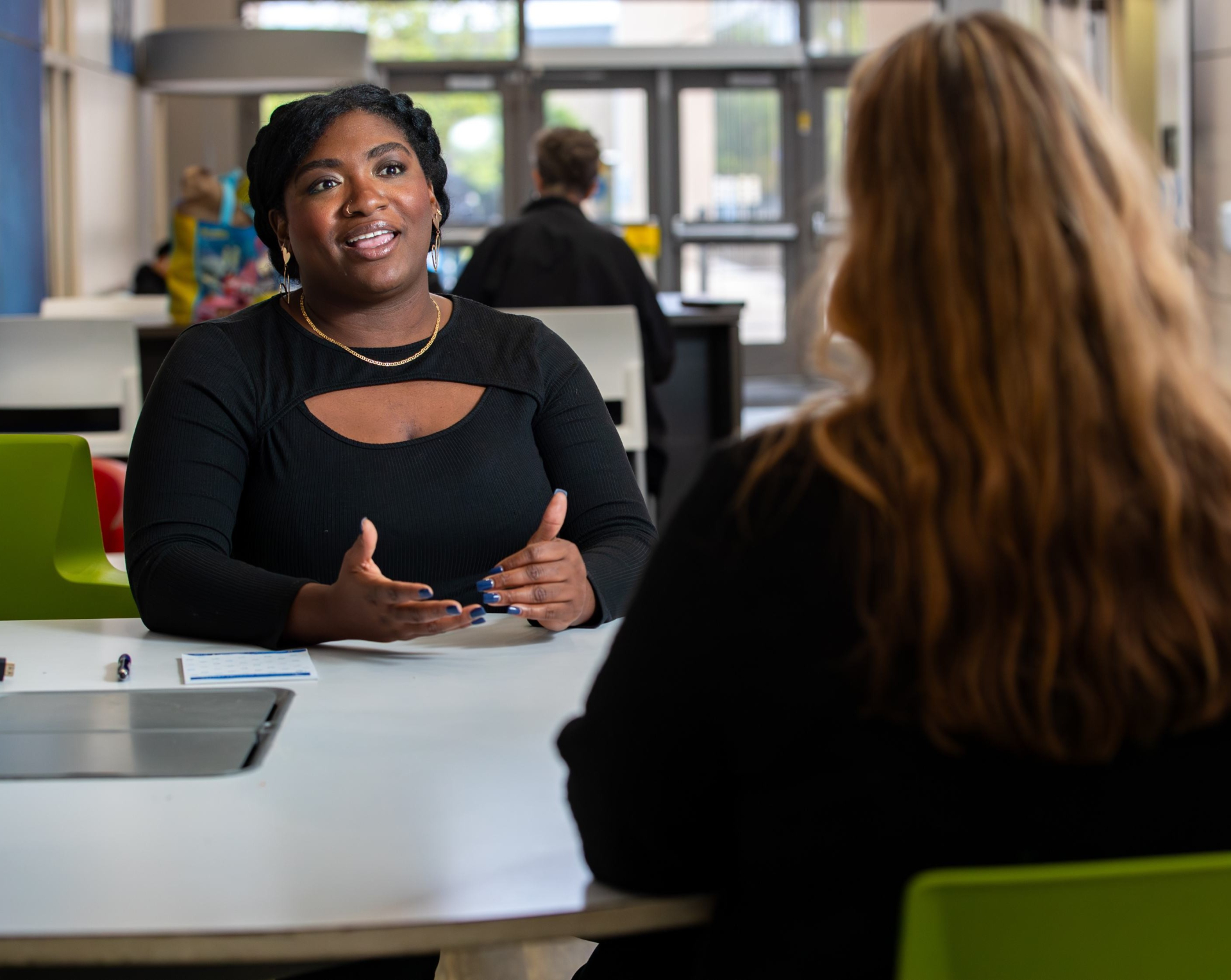 Marlena Brown sits at a desk and counsels a student.