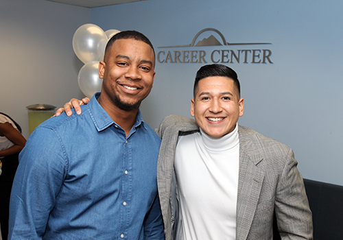 Photo of two individuals in front of a background with the words Career Center