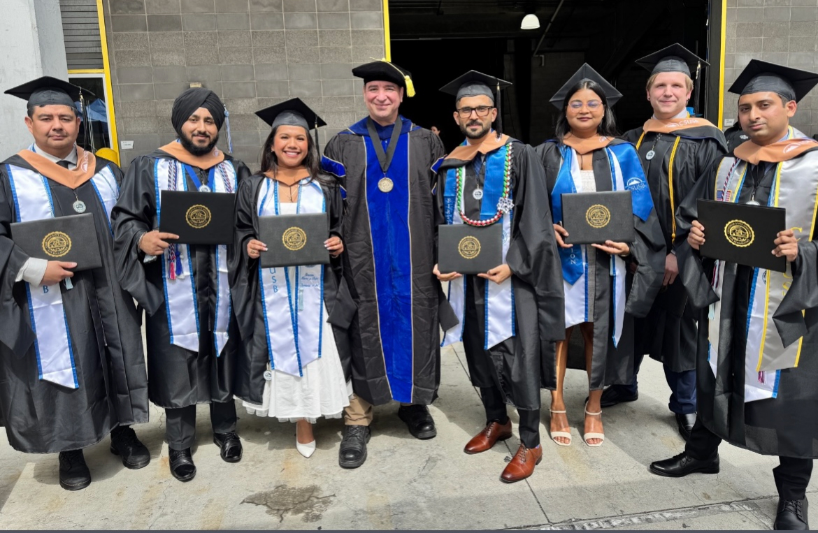 Gupta, third from right, at her graduation posing with Professor Vincent Nestler, center, and her classmates.