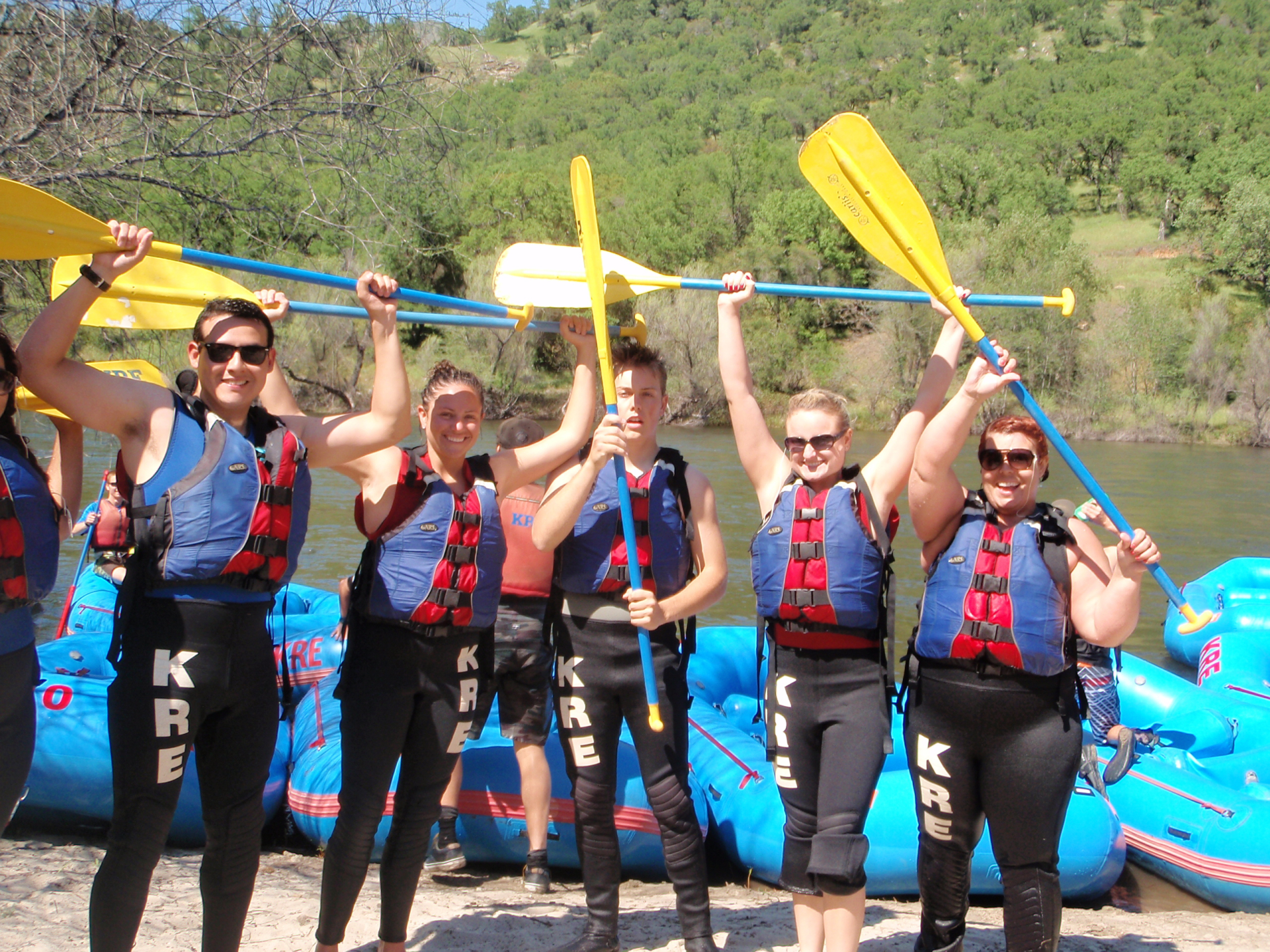 rafter on shore holding paddles