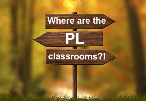 Where are the PL classrooms?!  A wooden signpost with arrows pointing in different directions.