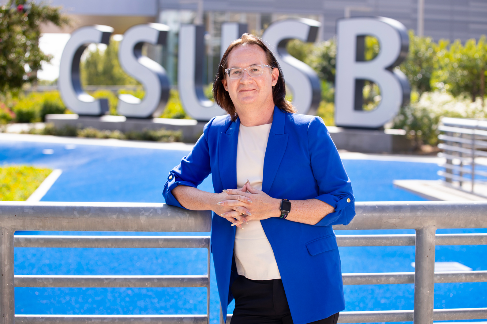 Hollins posing in front of the CSUSB letters and remembers their time on campus as a student.