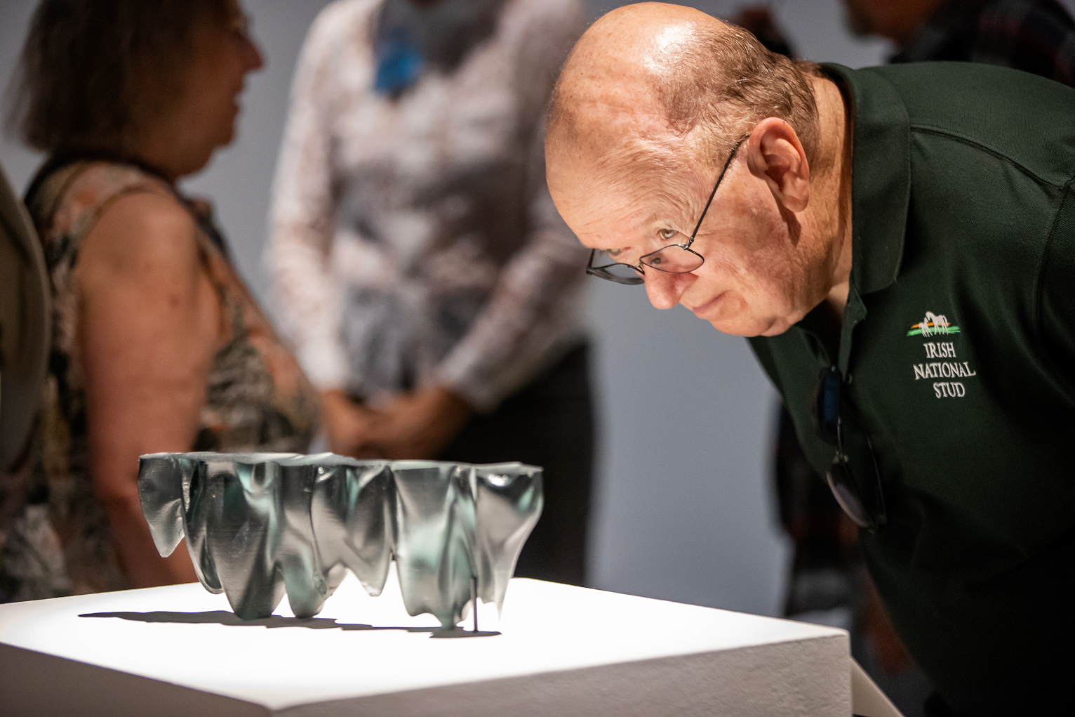 A visitor examines a piece in the "To See Through" exhibition.