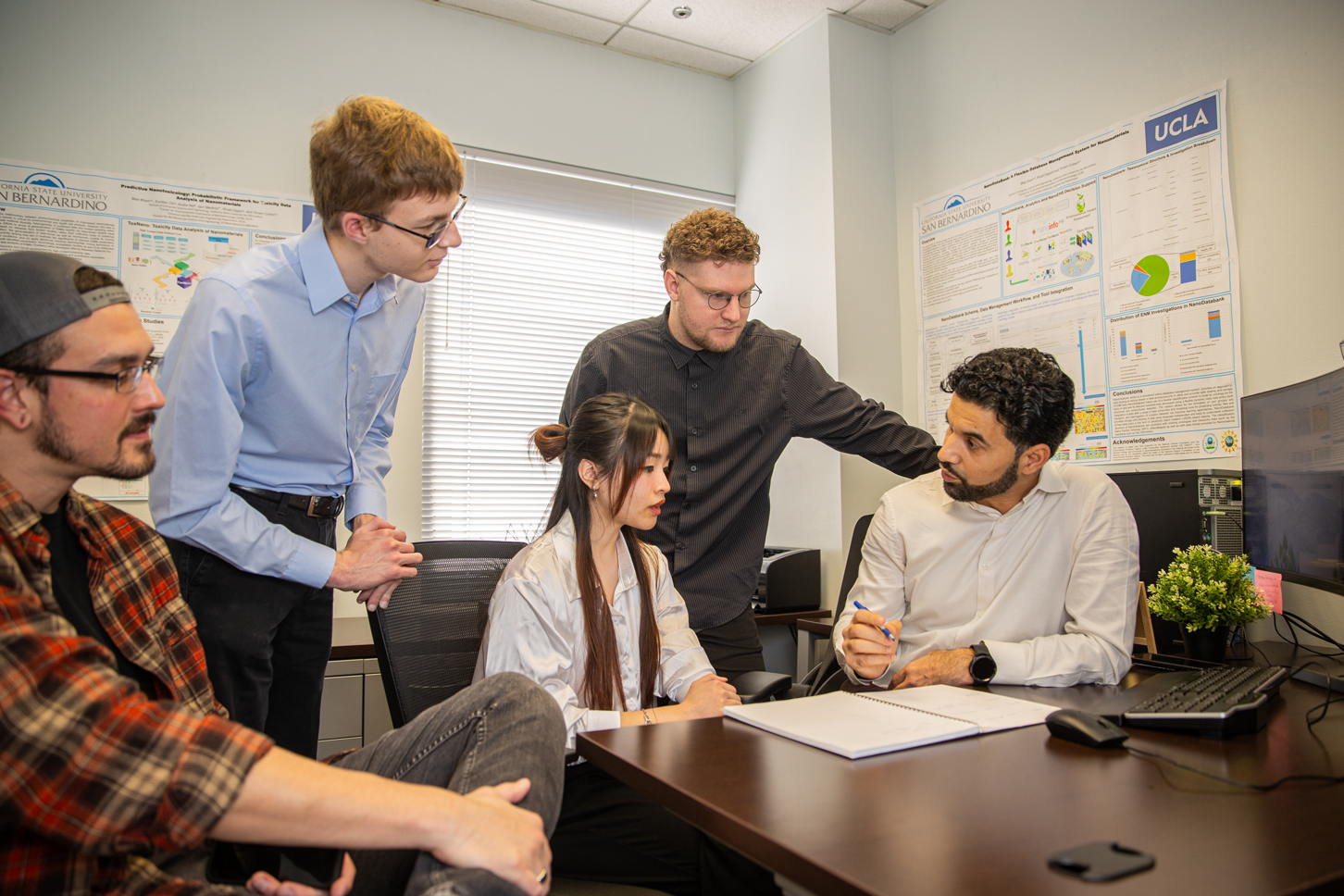 Khan, far right, talking with his students about a current research study.