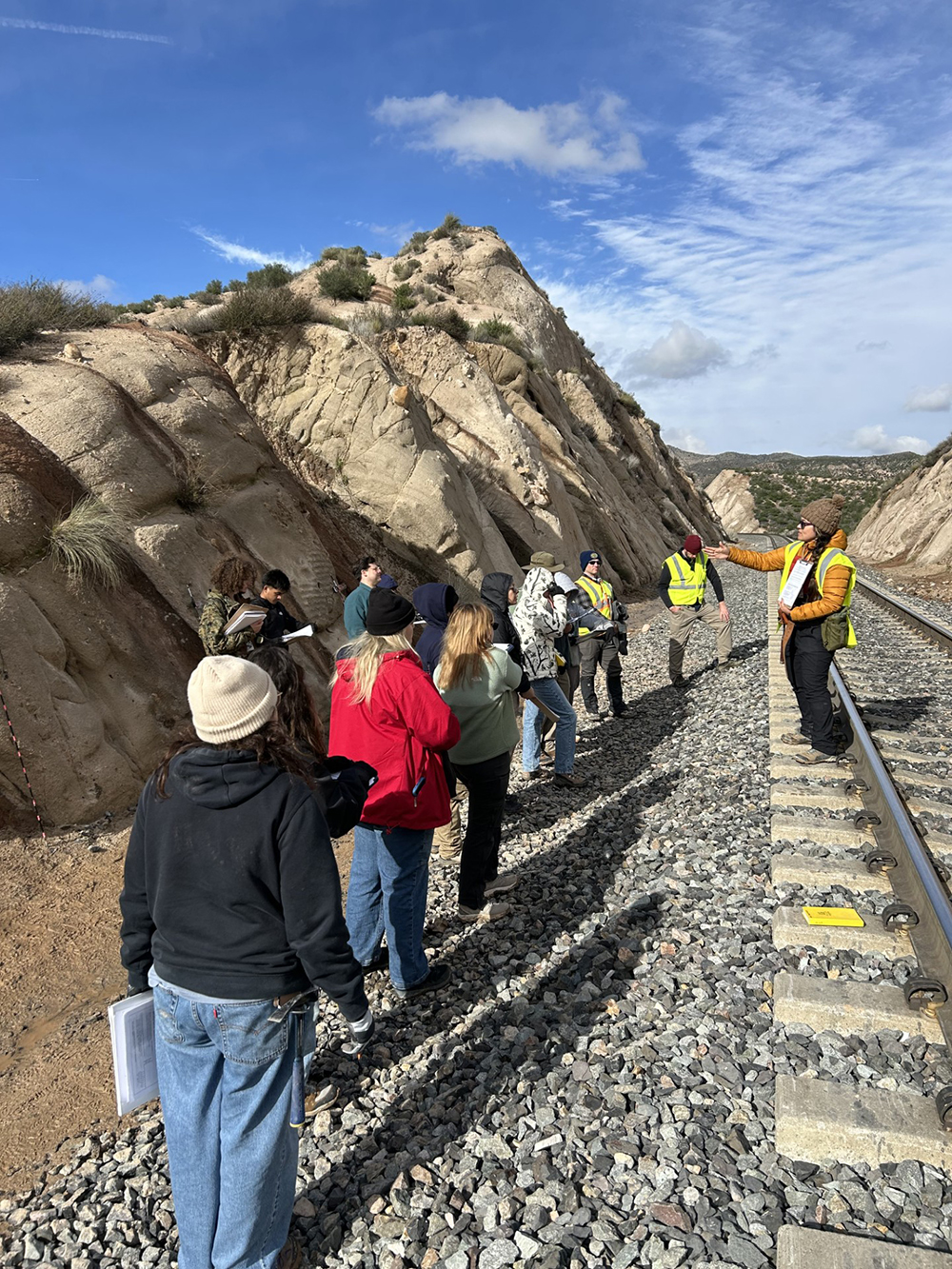 Susana Henriquez, assistant professor in CSUSB’s Department of Geological Sciences, instructs the students on how to describe stratigraphic sections at a railroad cut through the Cajon Valley Formation near Mormon Rocks in Phelan, Calif.