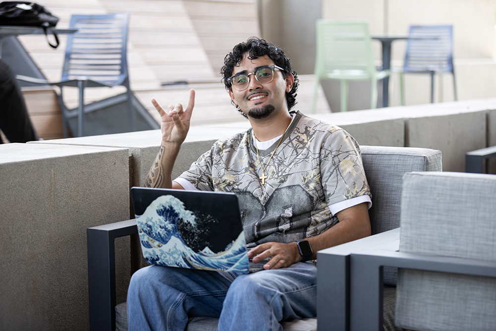 A student takes a break in front of the Santos Manuel Student Union North at CSUSB.&nbsp;