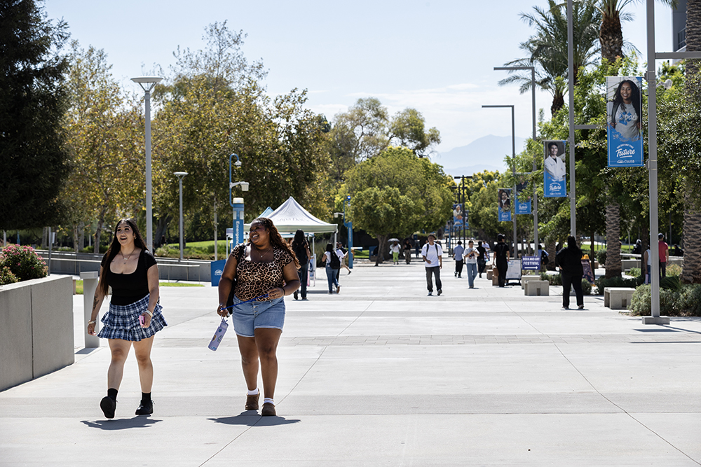 Students enjoy the day as they stroll down Coyote Walk at the main campus.&nbsp;