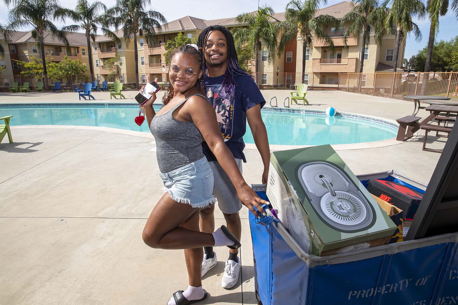 Two people by the pool at University Village during Move-in Days.