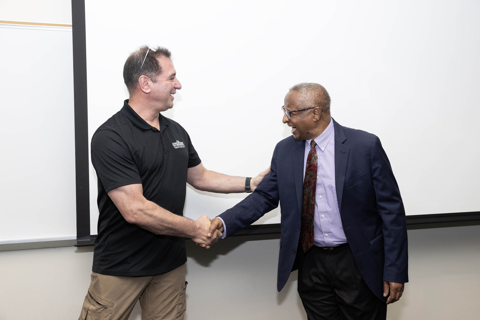 Vincent Nestler (left) is congratulated by Conrad Shayo, chair of the School of Cyber and Decision Sciences, after it was announced that Nestler was named the 2026 Outstanding Professor Award recipient