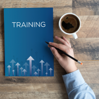 Blue booklet on a table that says "training" located next to a cup of coffee