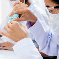 Student wearing a lab coat handling chemicals