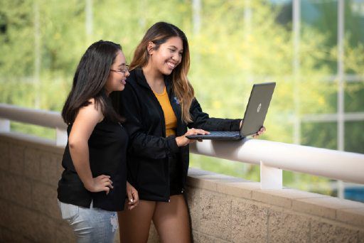 Two students viewing the 3d tour from a laptop