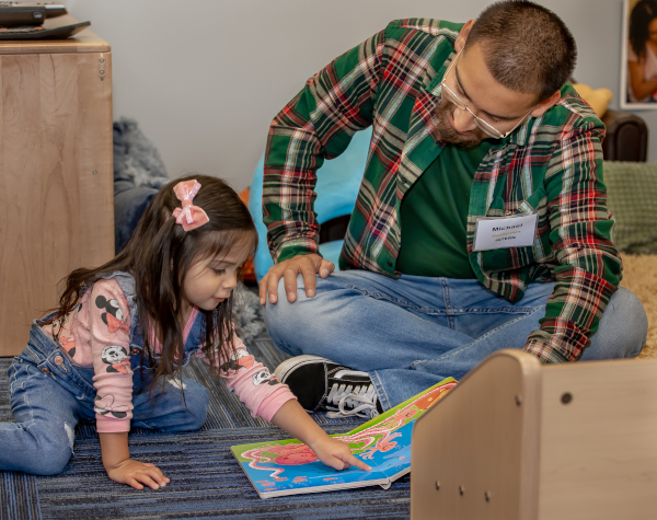 A child development student reads a book to a child