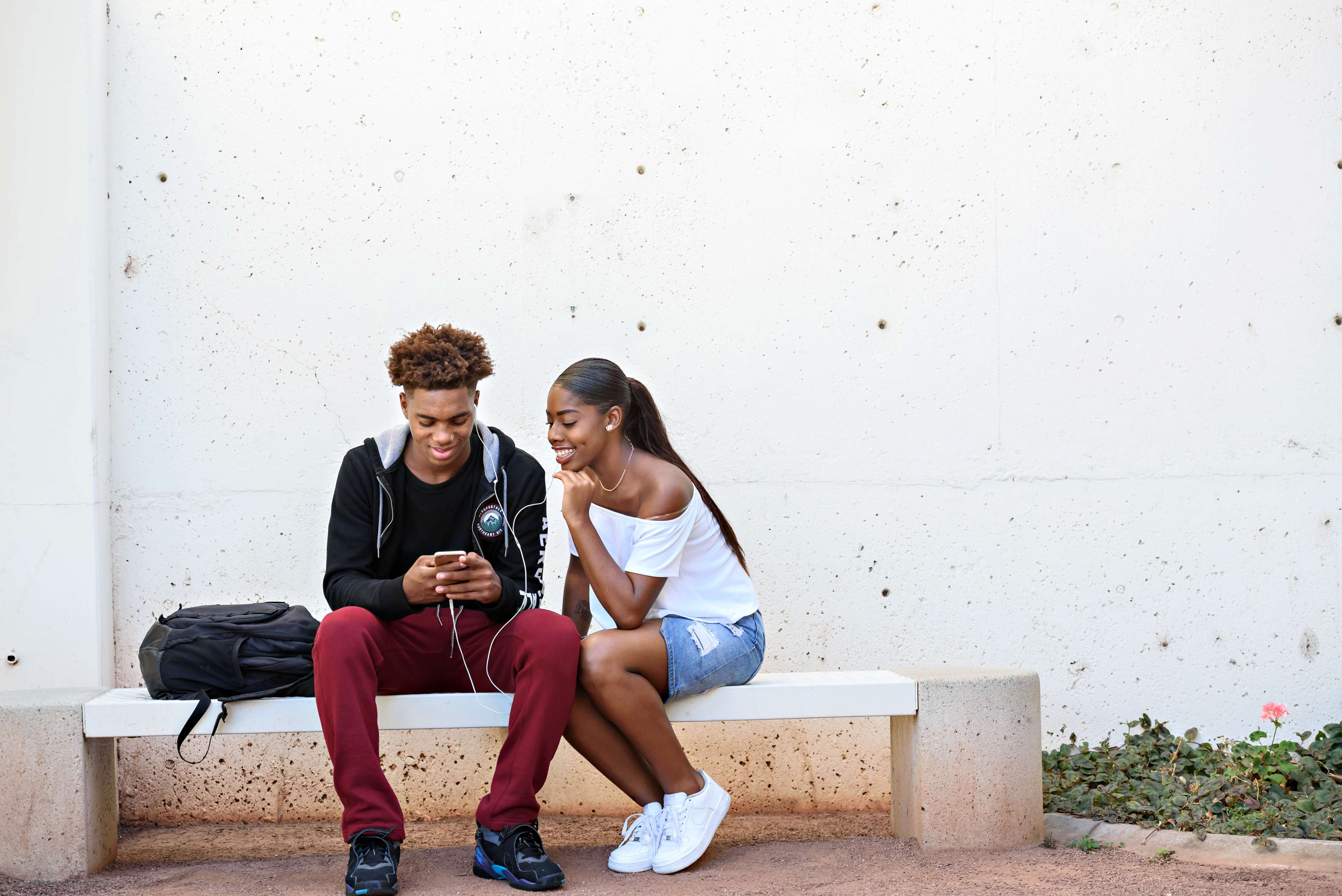 Students talking and laughing at a bench
