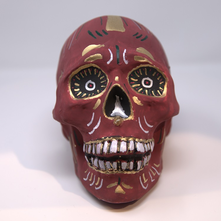 Red painted skull with black gold and silver colors.