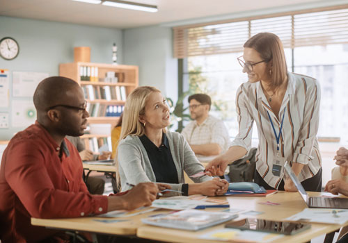Group of teachers talking in a classroom setting