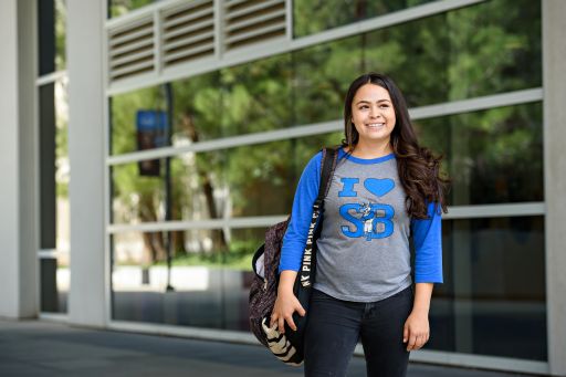 student posing with CSUSB T-shirt