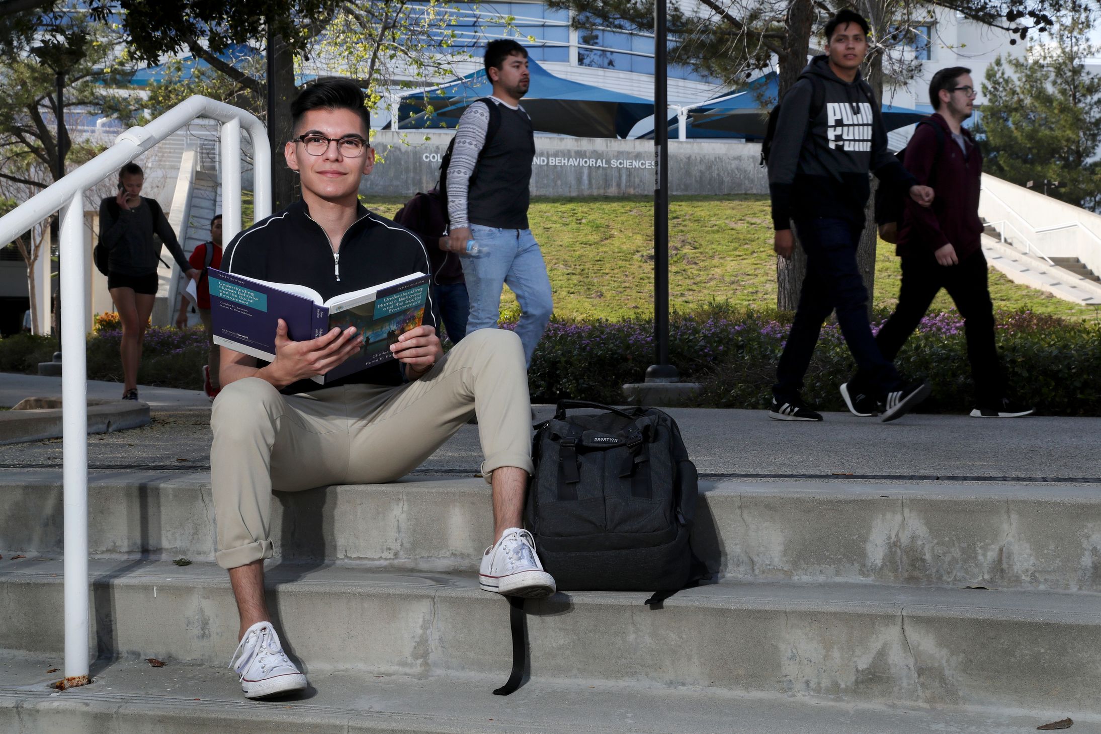 Student sitting down with a book.