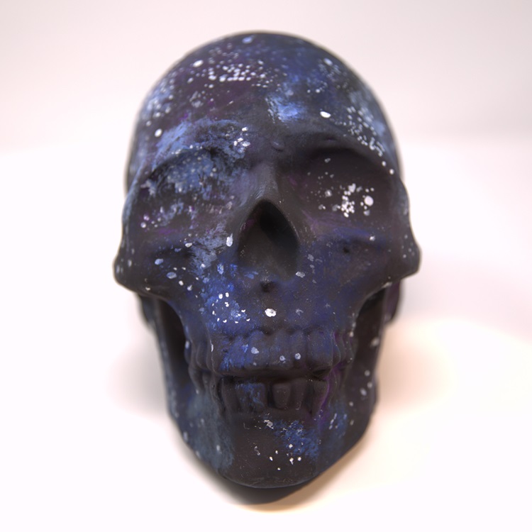 Matte black painted skull with blue, purple and white swatches to compose a space/galaxy pattern.