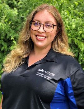 Elsa Sanchez, Transfer Student Success Counselor, wearing black and blue CSUSB polo and smiling