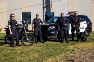 Members of the University Police Department at California State University, San Bernardino, standing in front of a patrol car, ready to serve and protect the campus community.