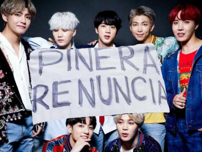 BTS Band with a poster that says "Pinera Renuncia."