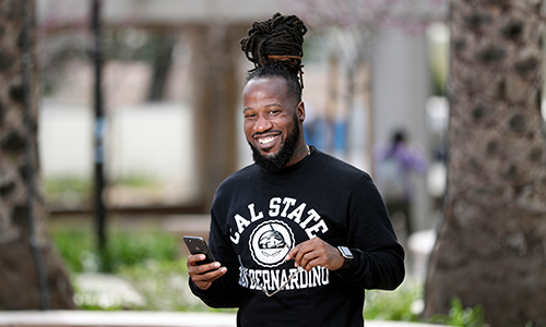 Student holding phone and smiling