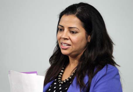 Woman holding papers speaking