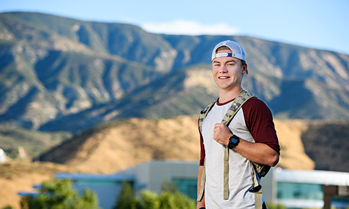 Student outside in front of mountains 