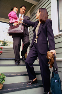 Man holding an infant as woman goes to work.