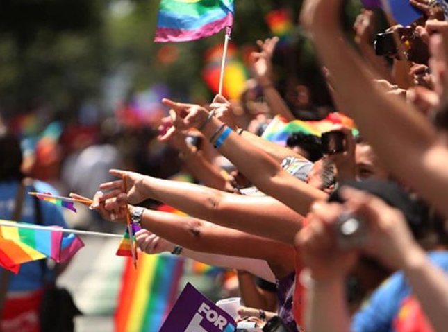 crowd waving pride flags.