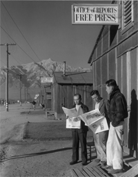 Roy Takeno, editor, and group reading paper in front of office