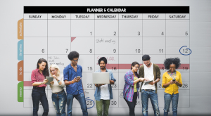 group of people looking at their devices in front of a calendar