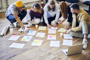 Group of people discussing paper on the floor