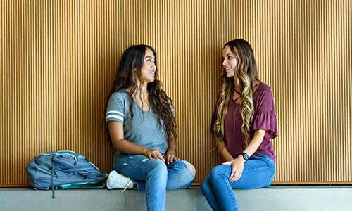 2 female students sitting talking