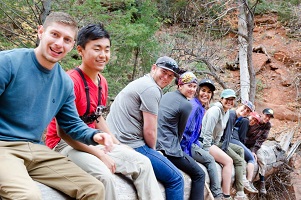 group of people sitting on a log in zion